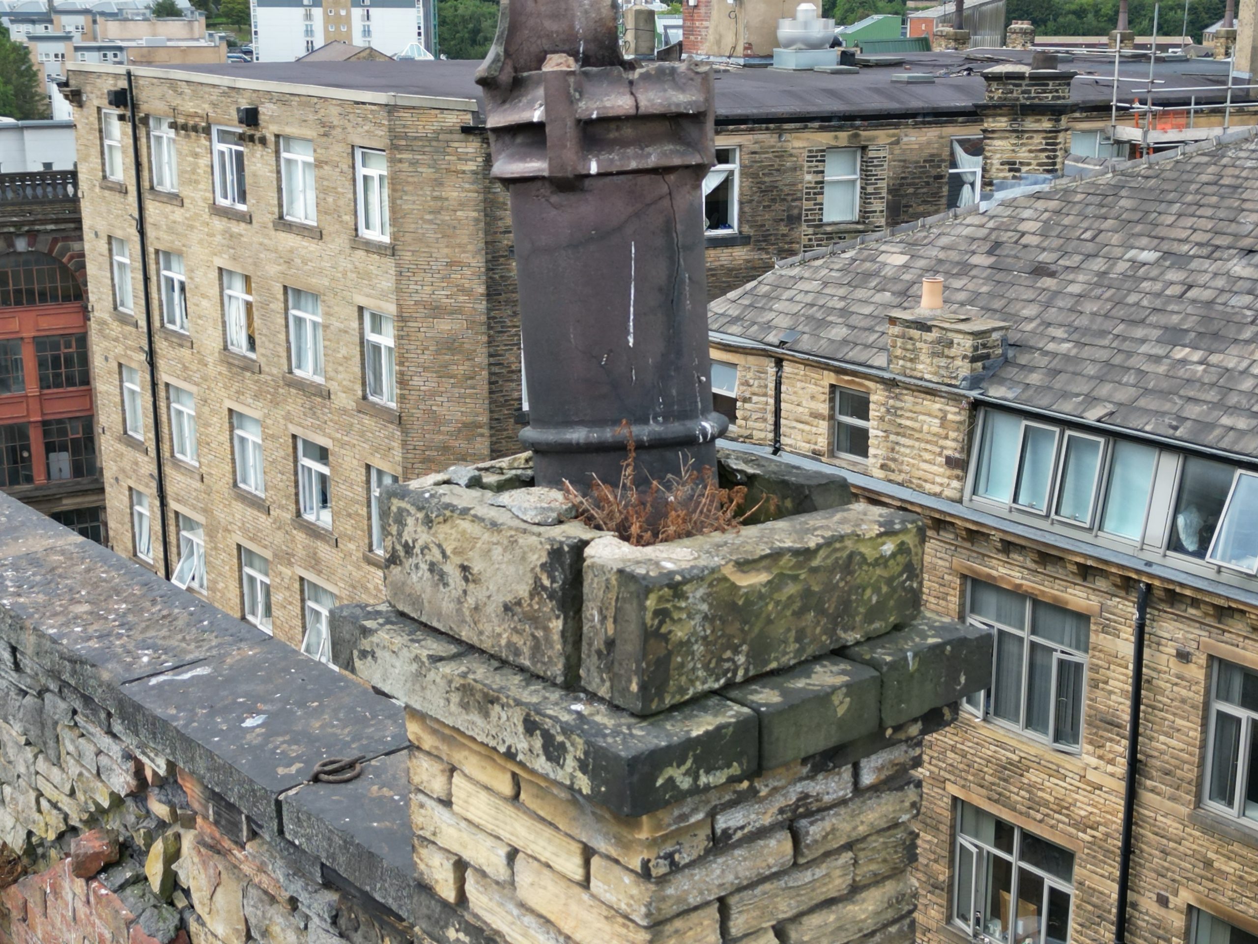 Restored brick chimney stack on a UK roof